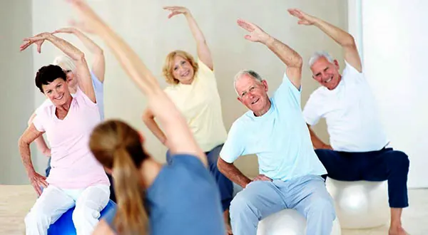 Personas mayores practicando Pilates en una clase de Fitball