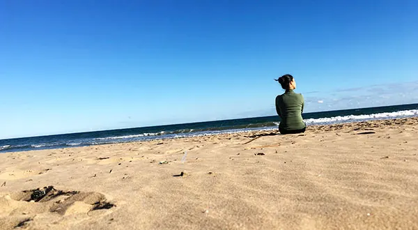 Fátima Pastor Andreu sentada en la arena de la playa
