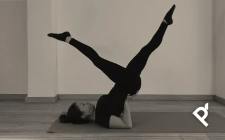 Fátima Pastor Andreu ejecutando el ejercicio de Pilates Mat The Scissors en el momento de la apertura de piernas en tijera