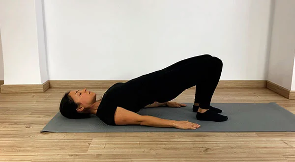 Fátima Pastor Andreu realizando el ejercicio de Pilates Mat The Shoulder Bridge, elevación de pelvis
