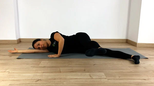 Posición de patada delante en The Side Kick. Fátima Pastor ejecutando el ejercicio de Pilates Mat