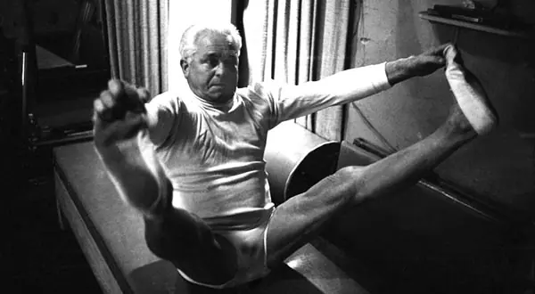 Joseph Pilates practicando Pilates sobre el Cadillac
