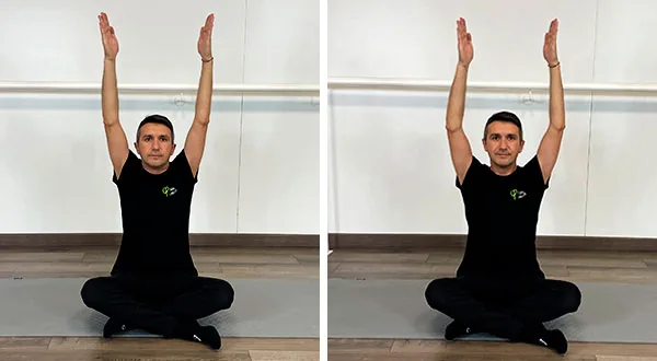 Vicente Juan Asencio sentado a lo indio elevando brazos. Imagen izquierda con desconexión escapular y derecha con conexión de escápulas. (Tips en Pilates)
