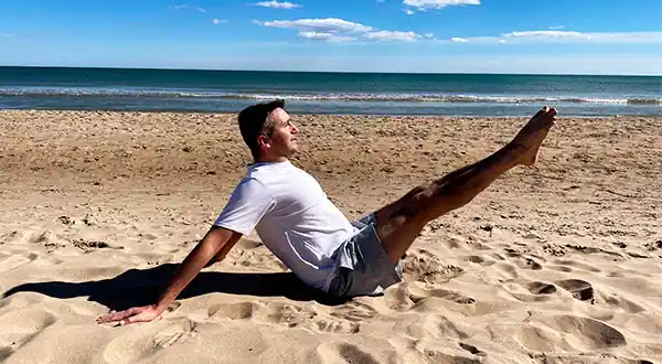 Vicente Juan Asecio en la playa haciendo un hip Circles de Pilates