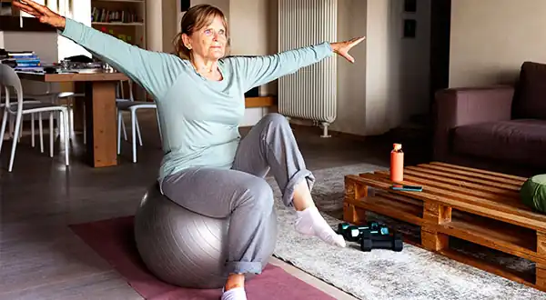 Mujer madura realizando un ejercicio de Pilates Mat con fitball